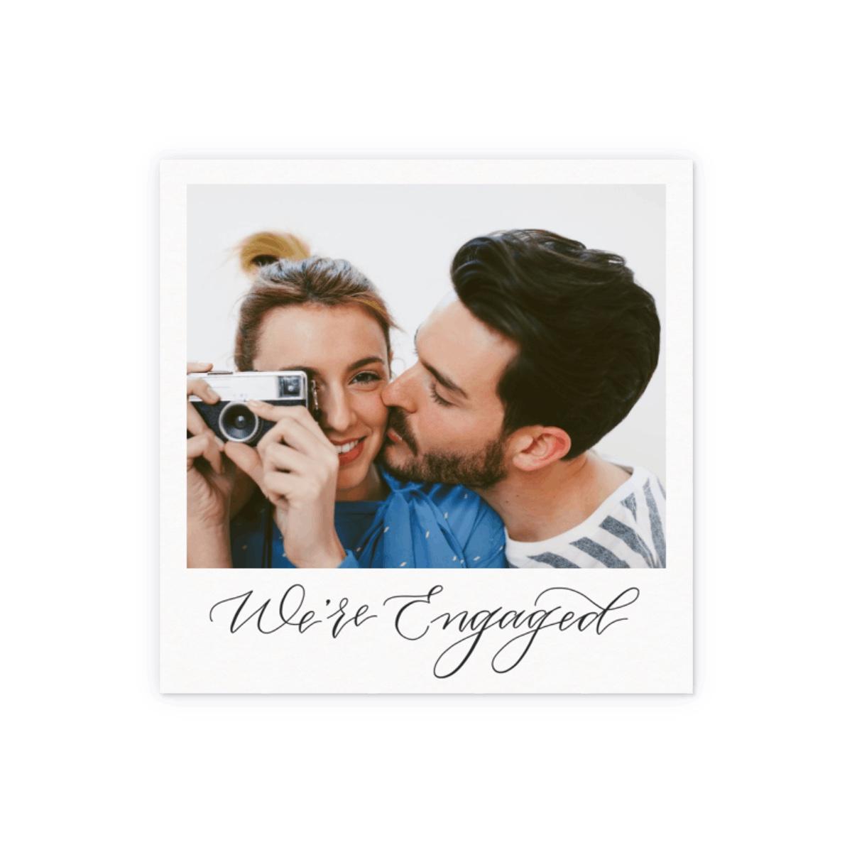 Square polaroid design with personalized photo and 'We're engaged' in black calligraphy
